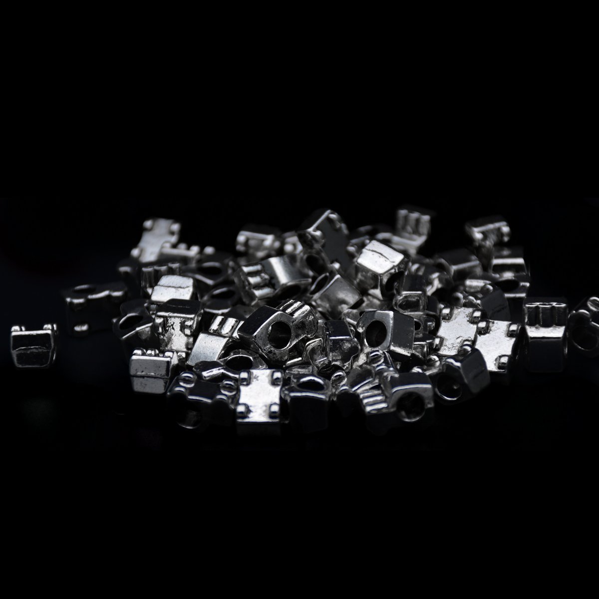 bulk of Antique silver car vehicle shape pandora beads scattering around in black background