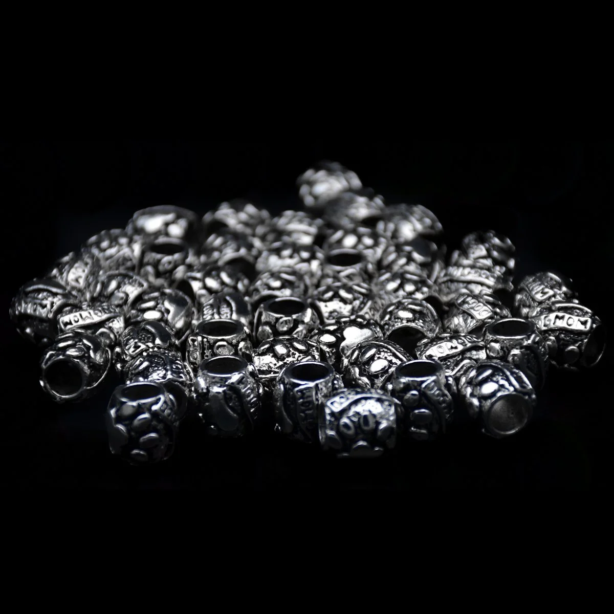 cylinder shape big hole antique silver pandora beads with words dog mum and dog paw pattern carved on the surface seems scattering around in the black background