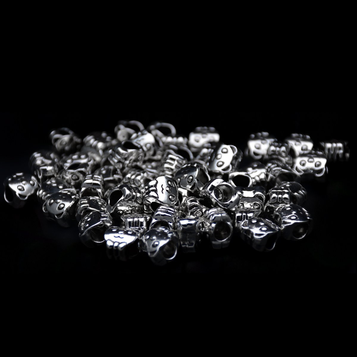 two Tibetan antique silver big hole beads with cute teddy bear head shape scattering around in a black background