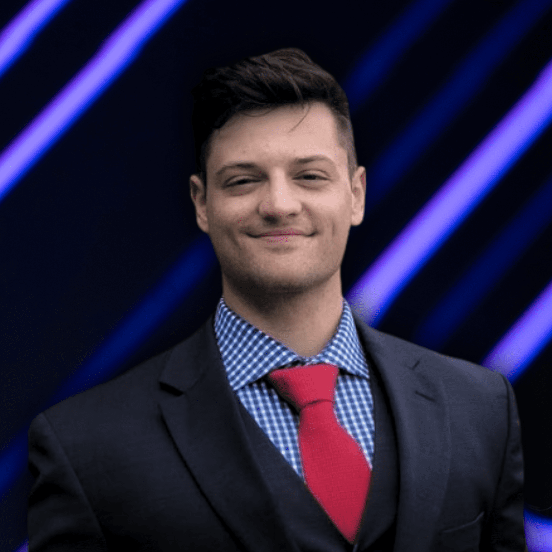 A young man in a suit and red tie smiling against a dark background with blue neon lines.