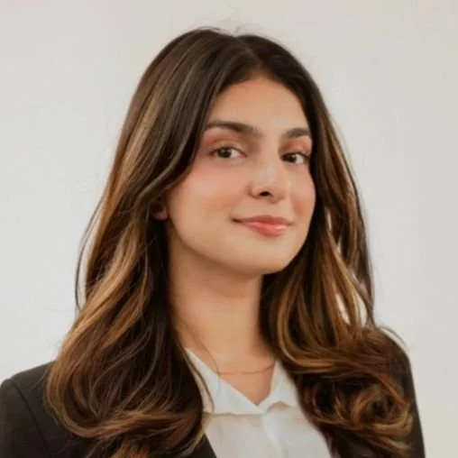Woman with dark brown hair and highlights in professional attire