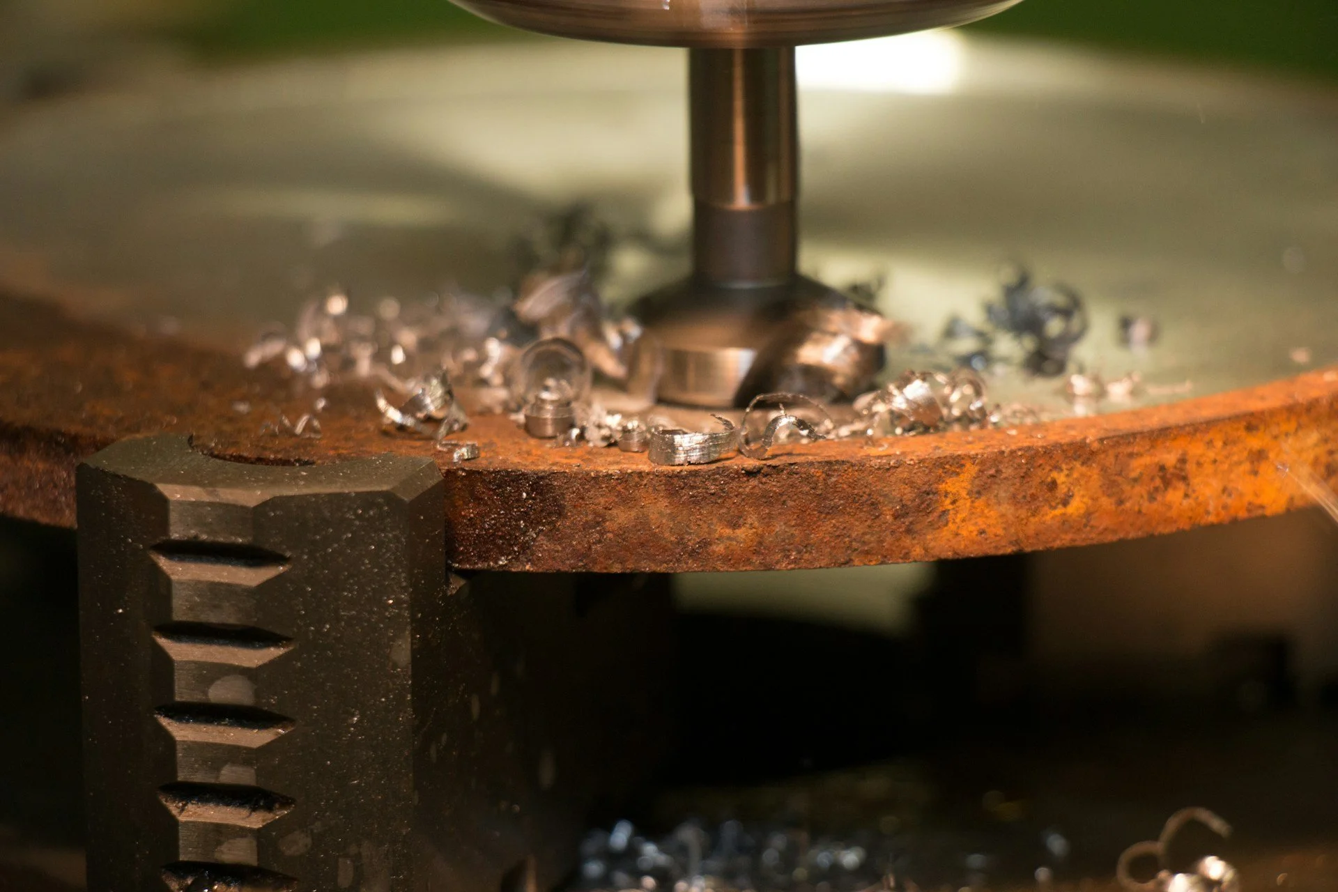 En metalborrmaskin som slipar en metallskiva, med metallspån runt om.