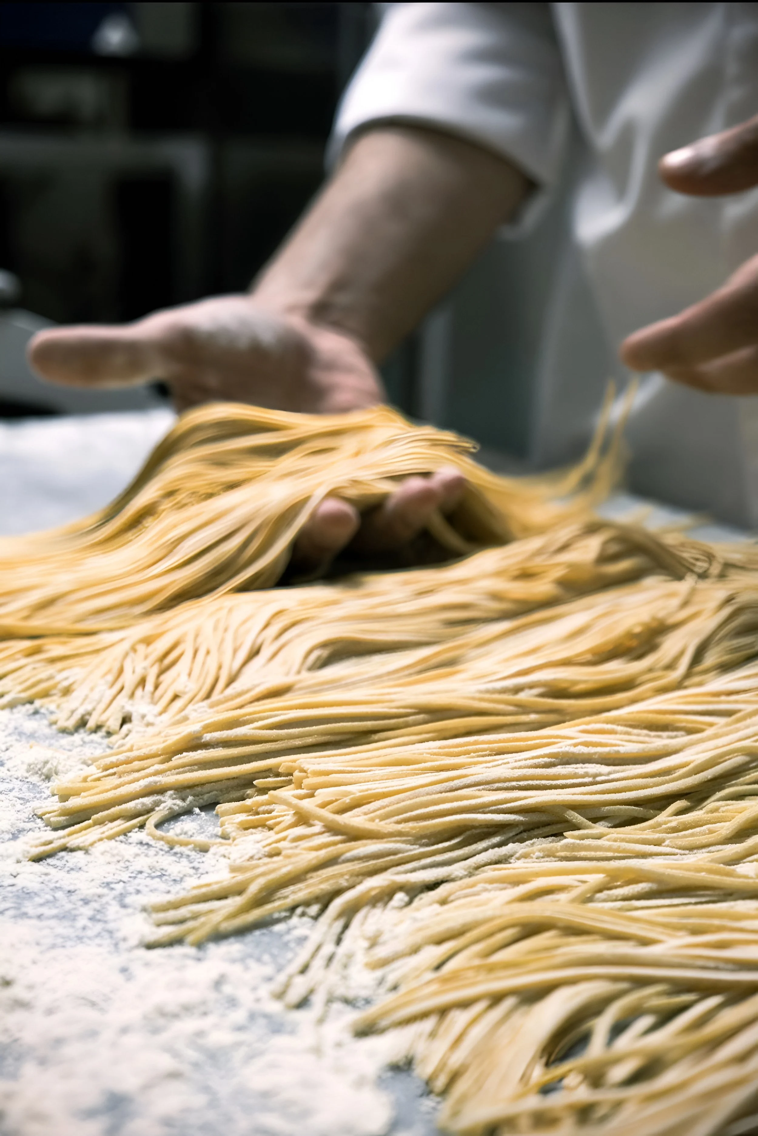 Persona che lavora la pasta fresca a mano in cucina