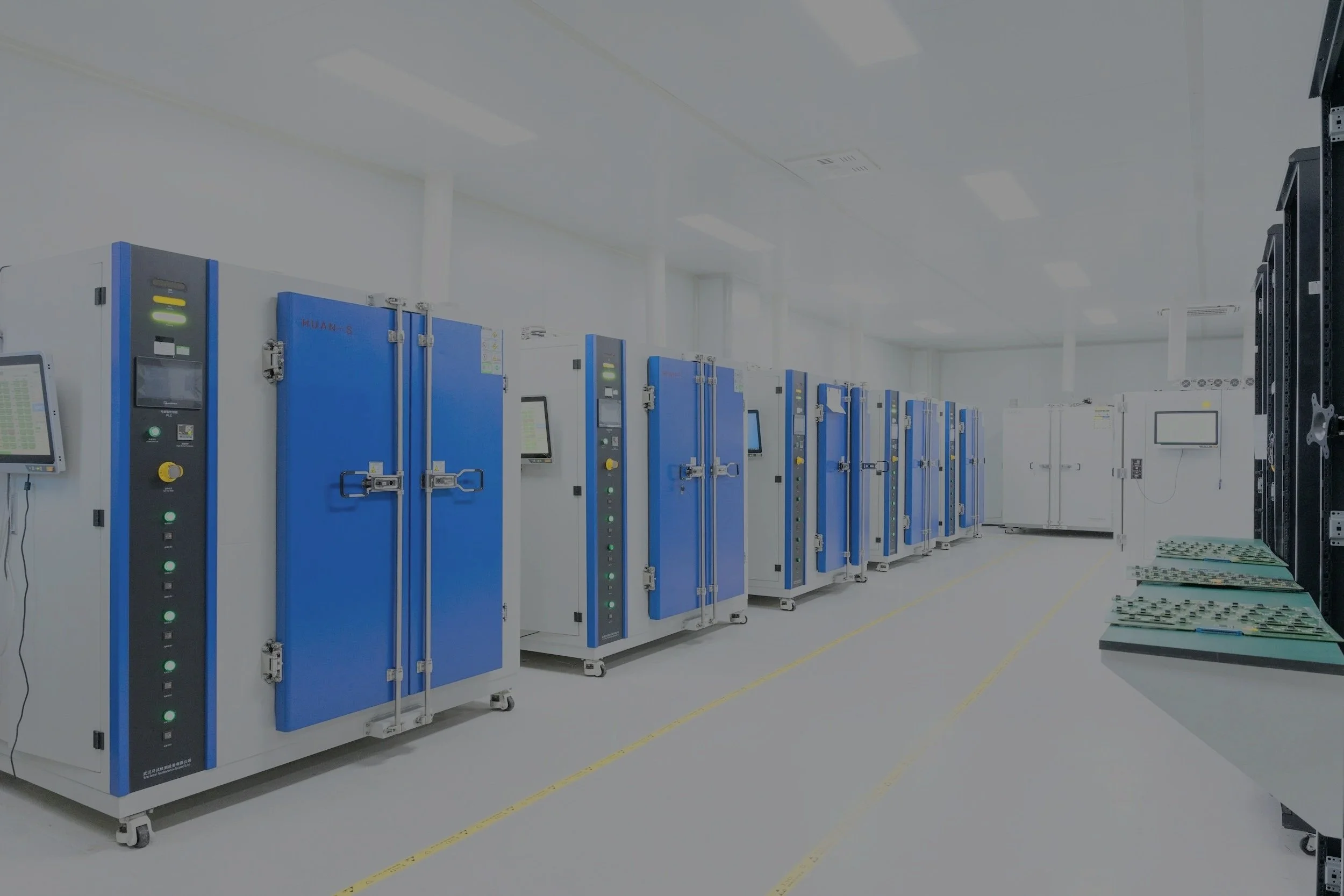 A clean, well-organized data center or server room with multiple blue and white server racks and electronic equipment, and a flat-screen monitor on the left side.
