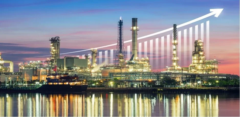 Industrial factory with smokestacks at sunset, overlaid with an upward trending graph line.