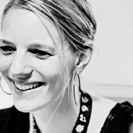 Ein Lächelndes blondes Frau, Schulteransicht, in Schwarz-Weiß.