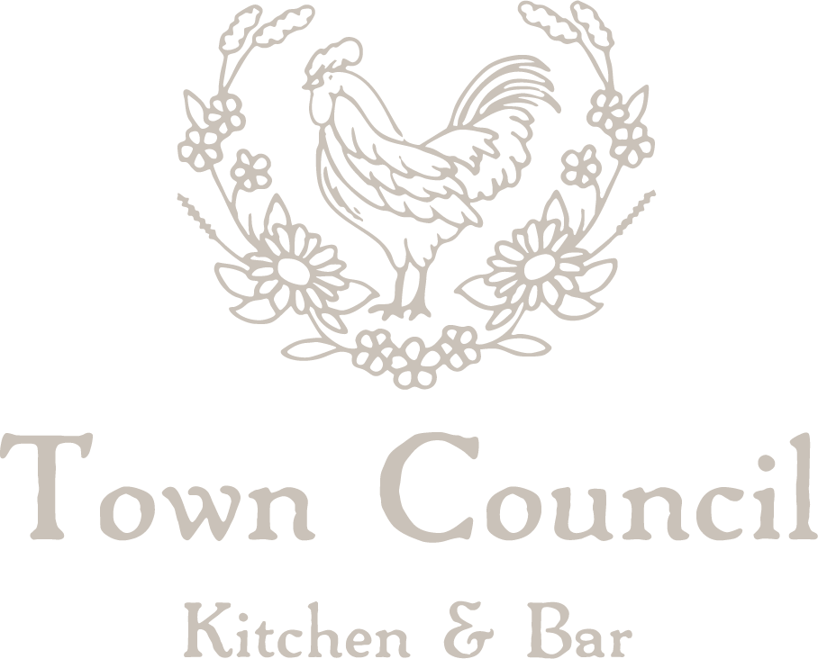 Logo for Town Council Kitchen & Bar featuring a rooster surrounded by flowers and foliage.