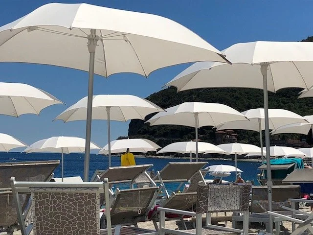 The beach with umbrellas in Noli at Ligurian coast.