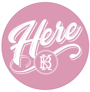 Pink circular logo with white cursive text that says 'Here' and a smaller circular emblem with initials 'KB' inside.