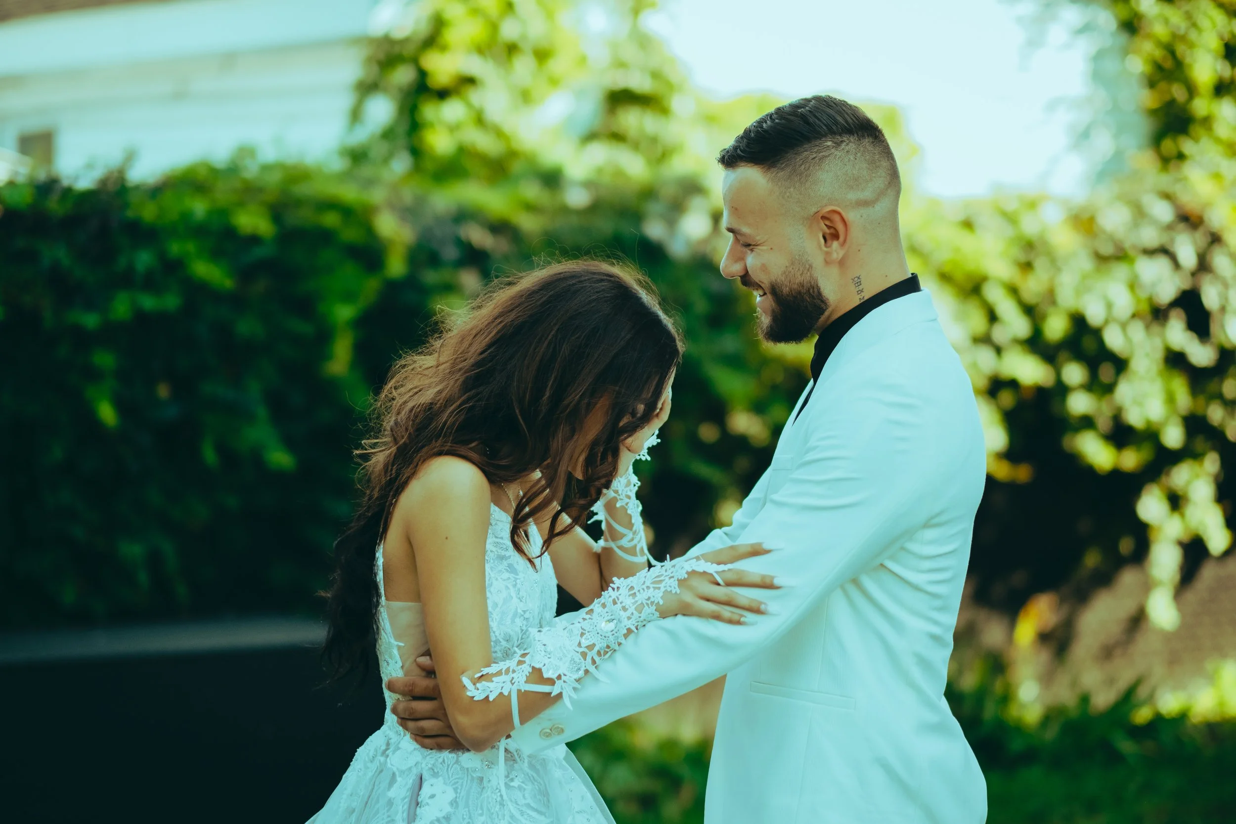 Videographer in Montreal capturing professional music videos, corporate videos, and live events. High-quality video production services in Montreal.A bride and groom smiling and embracing outdoors, with greenery in the background.