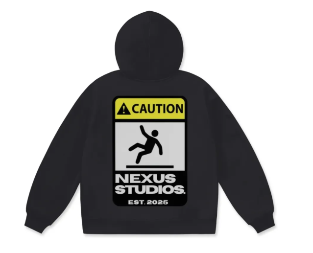 Black hooded sweatshirt featuring a warning sign and graphic of a falling person, with text that reads "CAUTION NEXUS STUDIOS. EST. 2025."