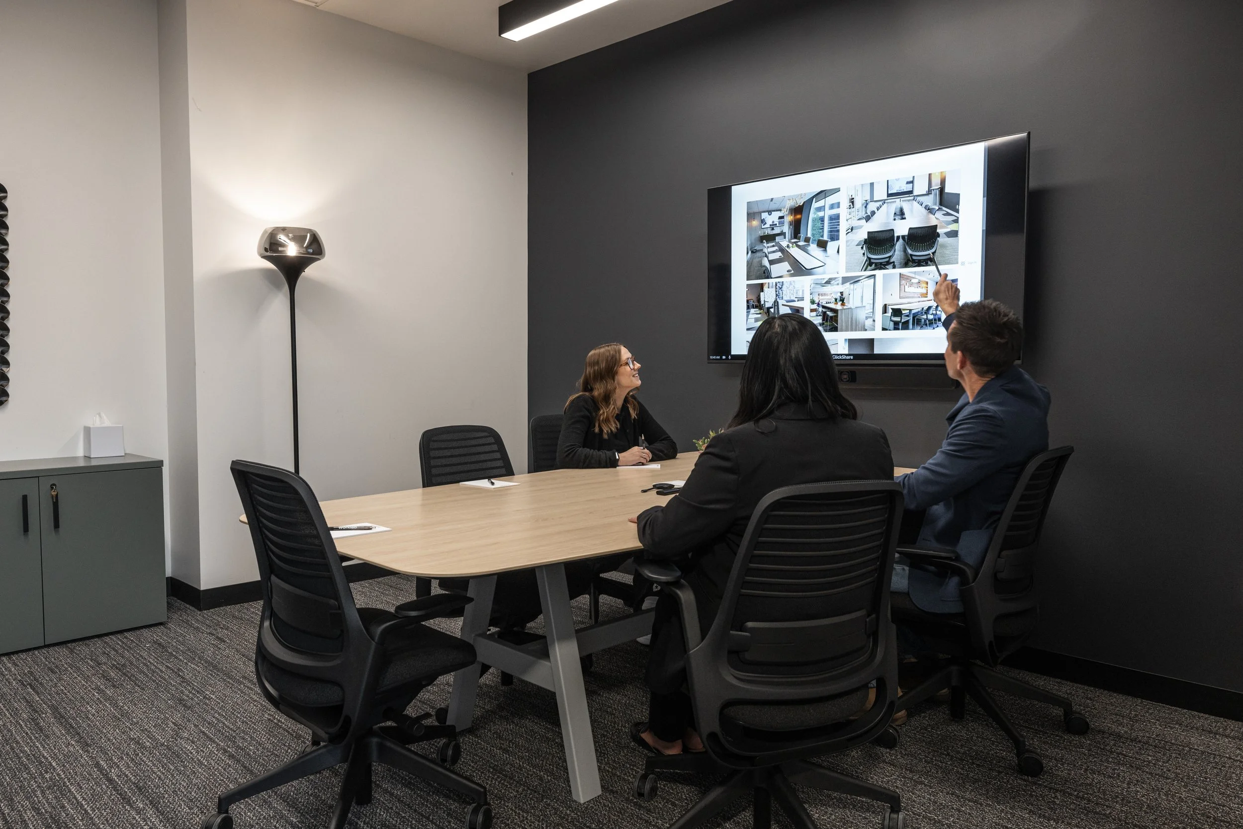 Person sitting at a desk holding a pen and a notebook, with a black coffee mug labeled 'worklab' nearby.