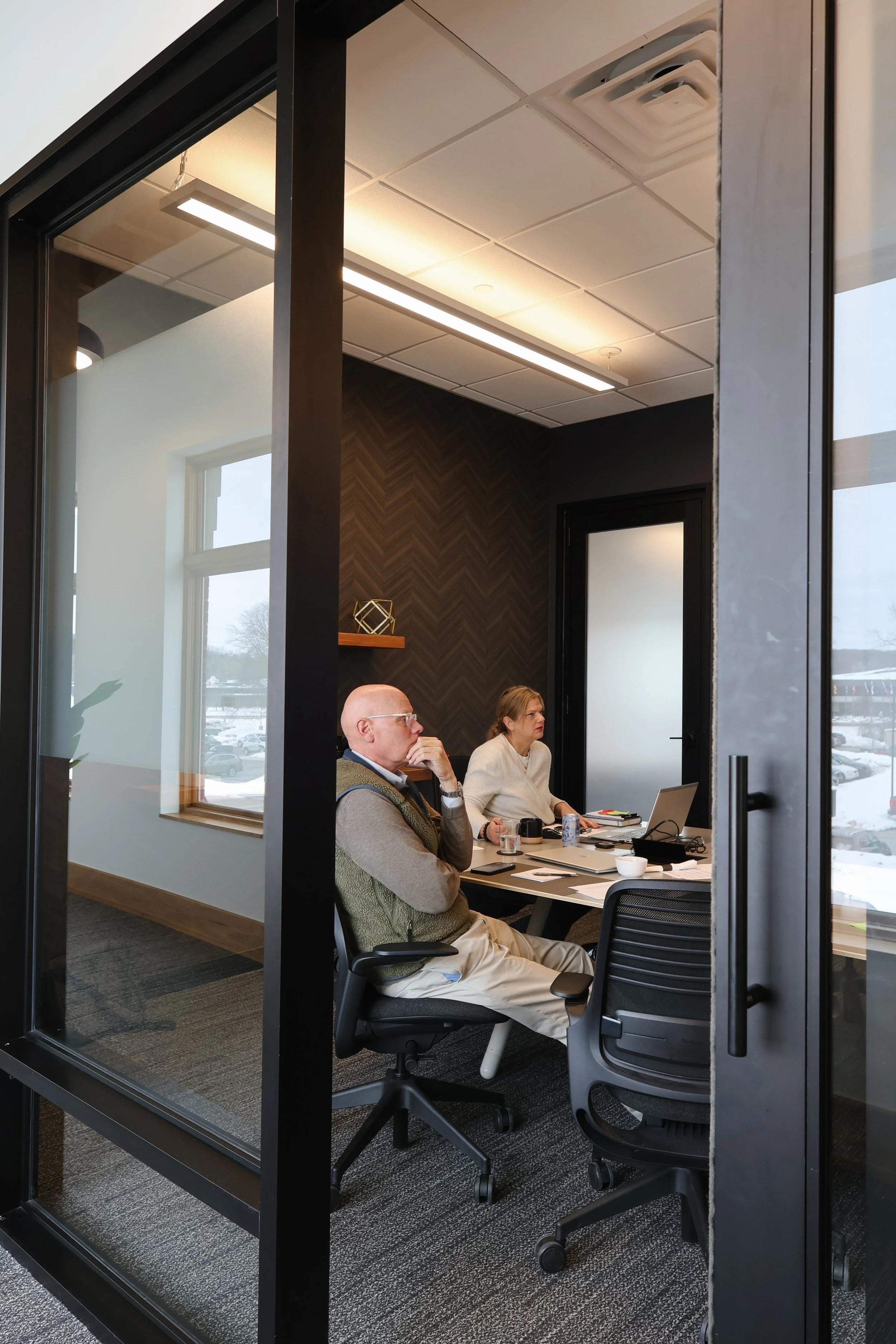 Person sitting at a desk holding a pen and a notebook, with a black coffee mug labeled 'worklab' nearby.
