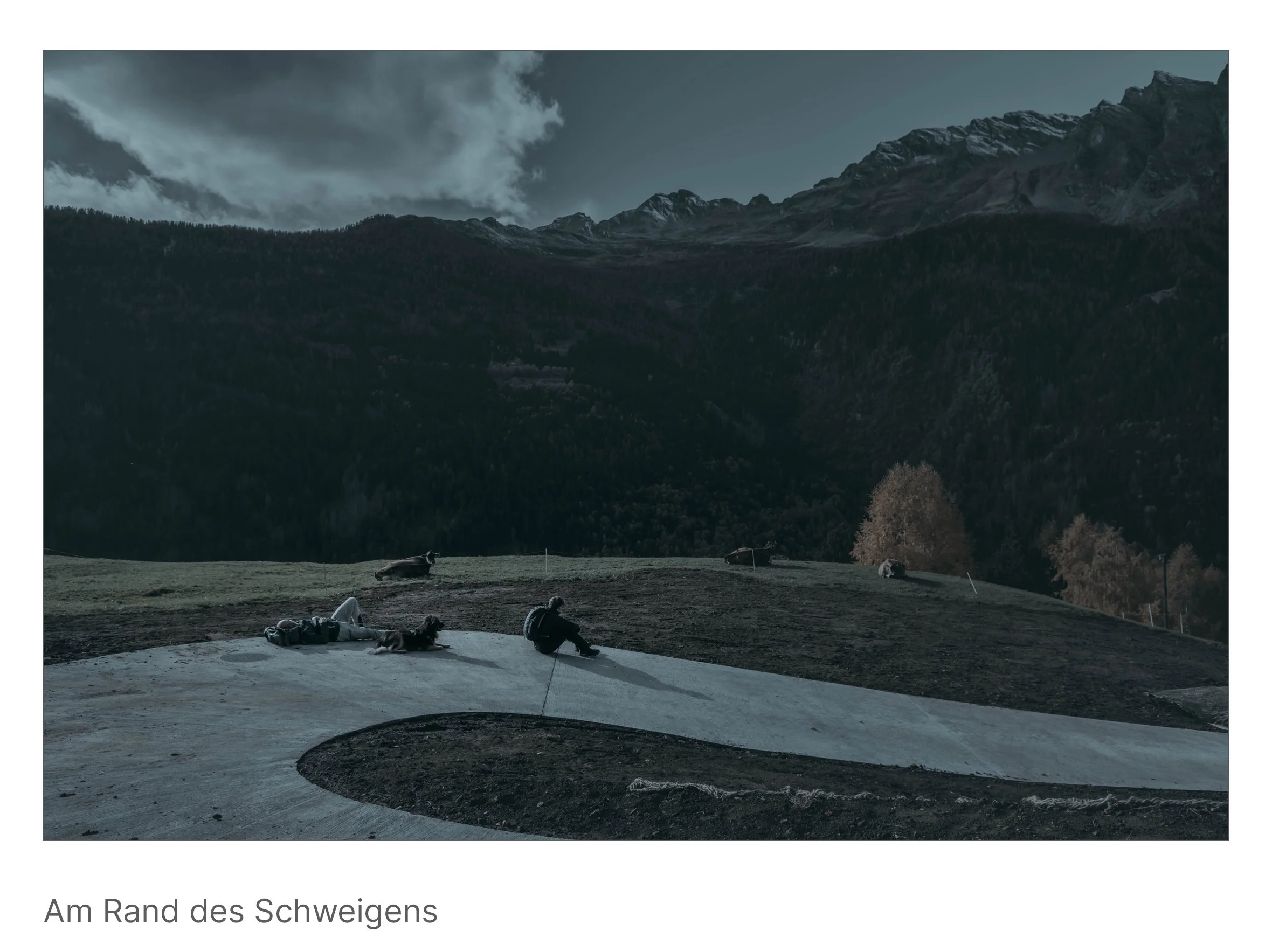 Eine offene Bergwiese, Menschen ruhen in der Weite, der Blick reicht bis zu fernen Gipfeln unter kühlem Licht – ein Ort des Innehaltens.