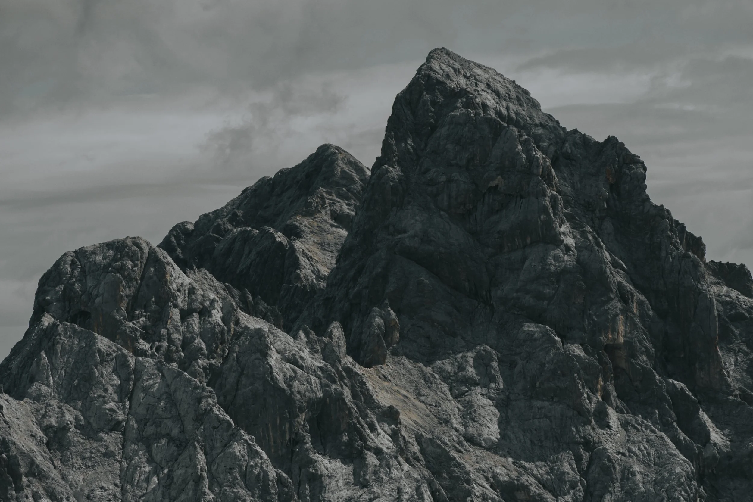 Felsgipfel
Nahaufnahme eines schroffen alpinen Felsgipfels mit markanten Gesteinsstrukturen unter bedecktem Himmel – Bergfotografie von ReBlick.