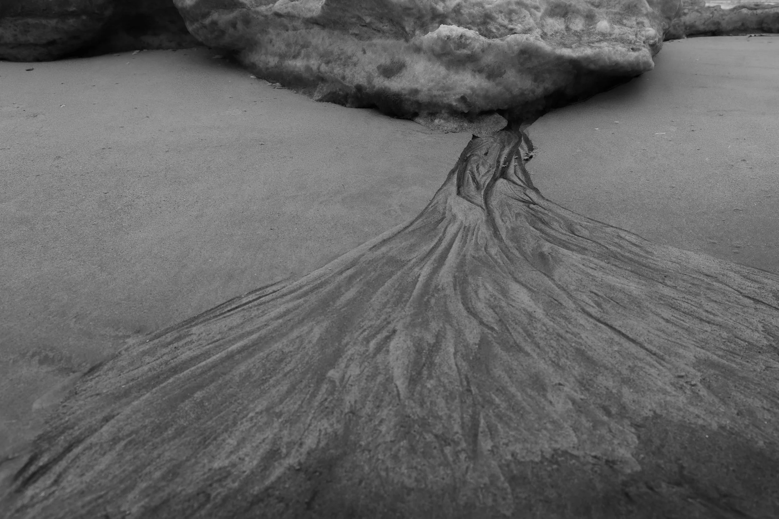 Abfluss
Schmelzwasser zeichnet feine Verästelungen in den Sand und verbindet Eis und Küstenboden zu einer vergänglichen Struktur.