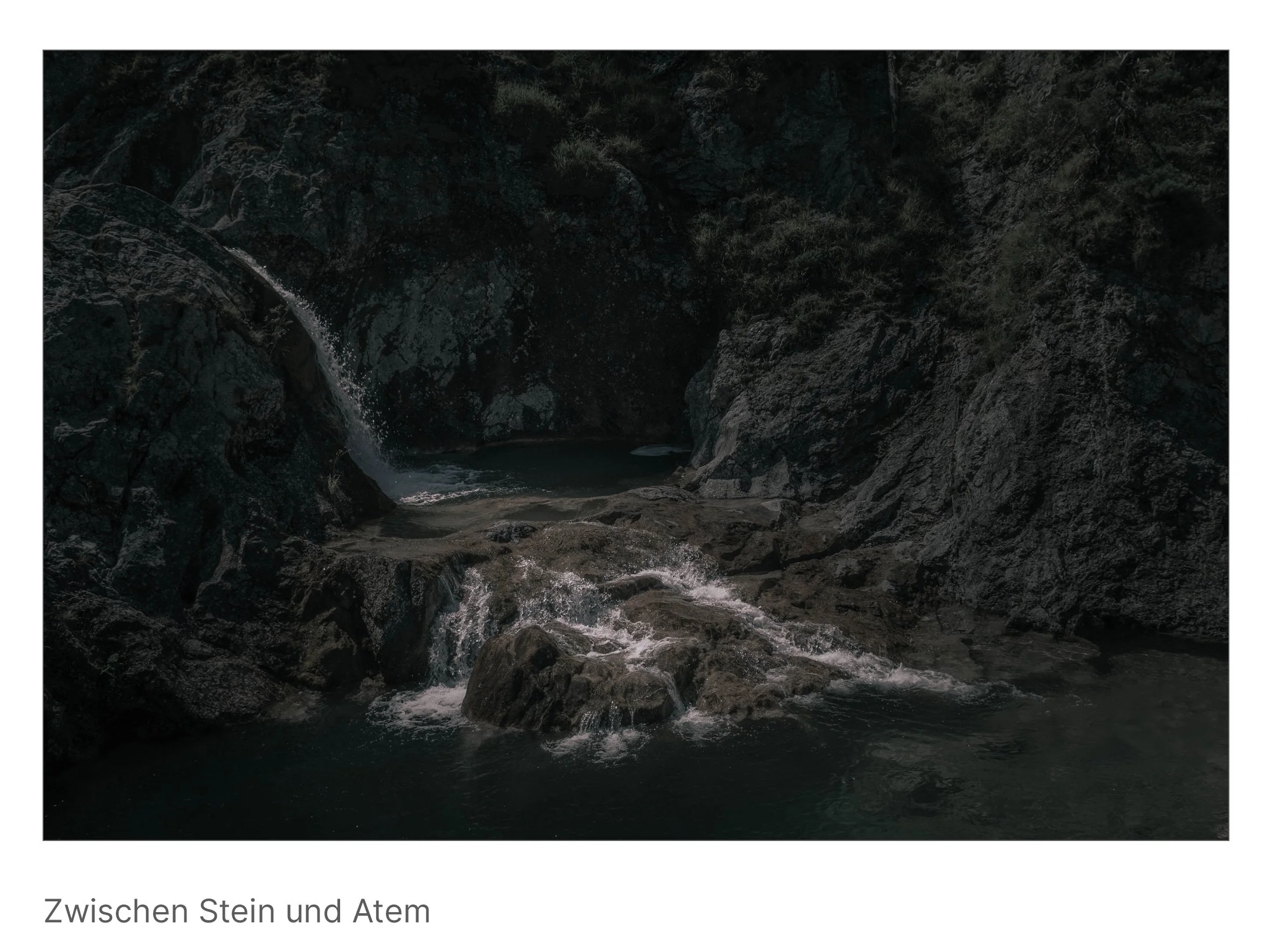 Klares Wasser umspült dunkle Felsen, Lichtreflexe tanzen – eine Balance zwischen Schwere und Leichtigkeit.