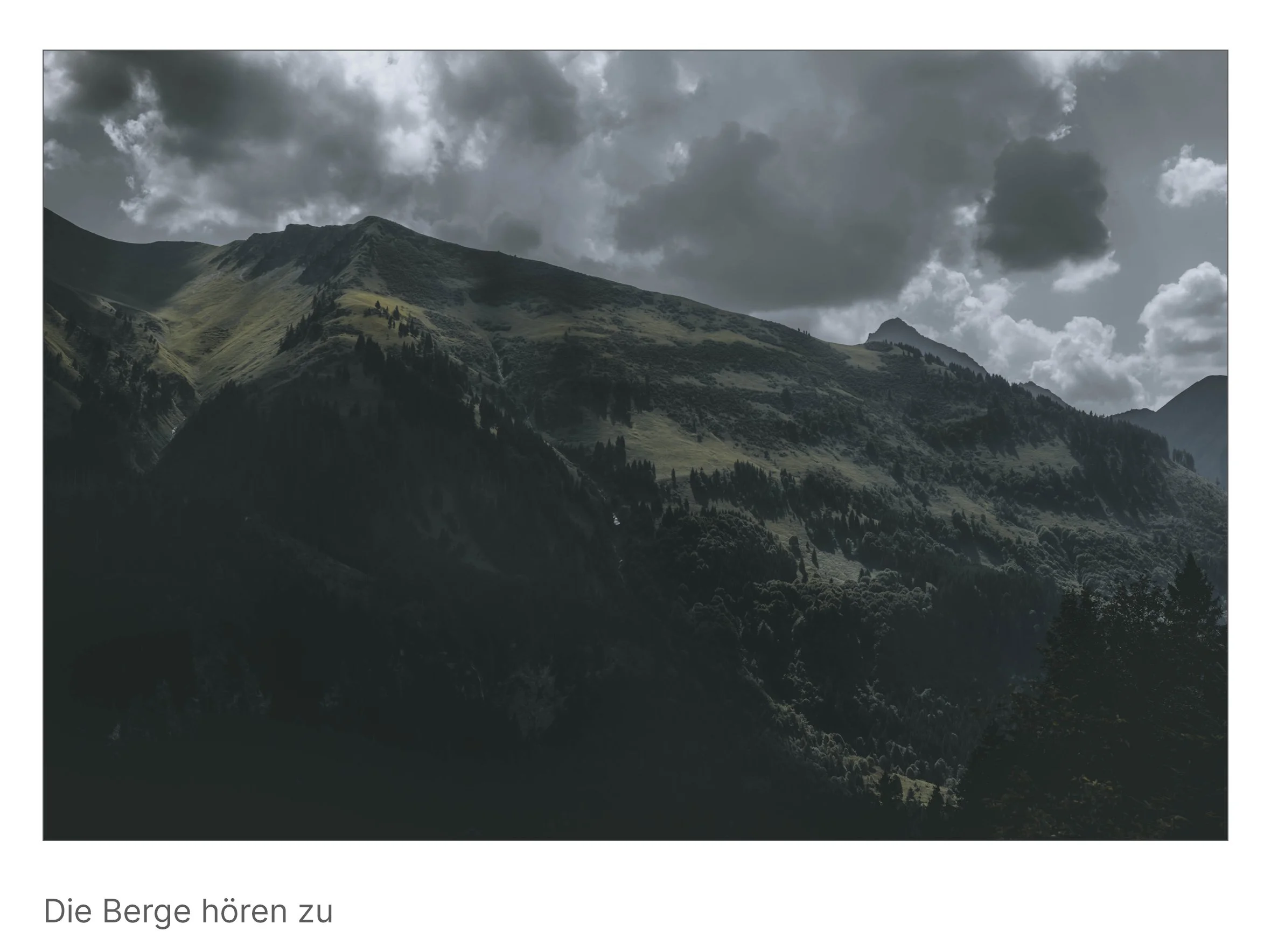 Von Wolken überzogene Bergflanken im Zwielicht, Sonne tastet über die Hänge – Sinnbild für Wahrnehmung ohne Worte.