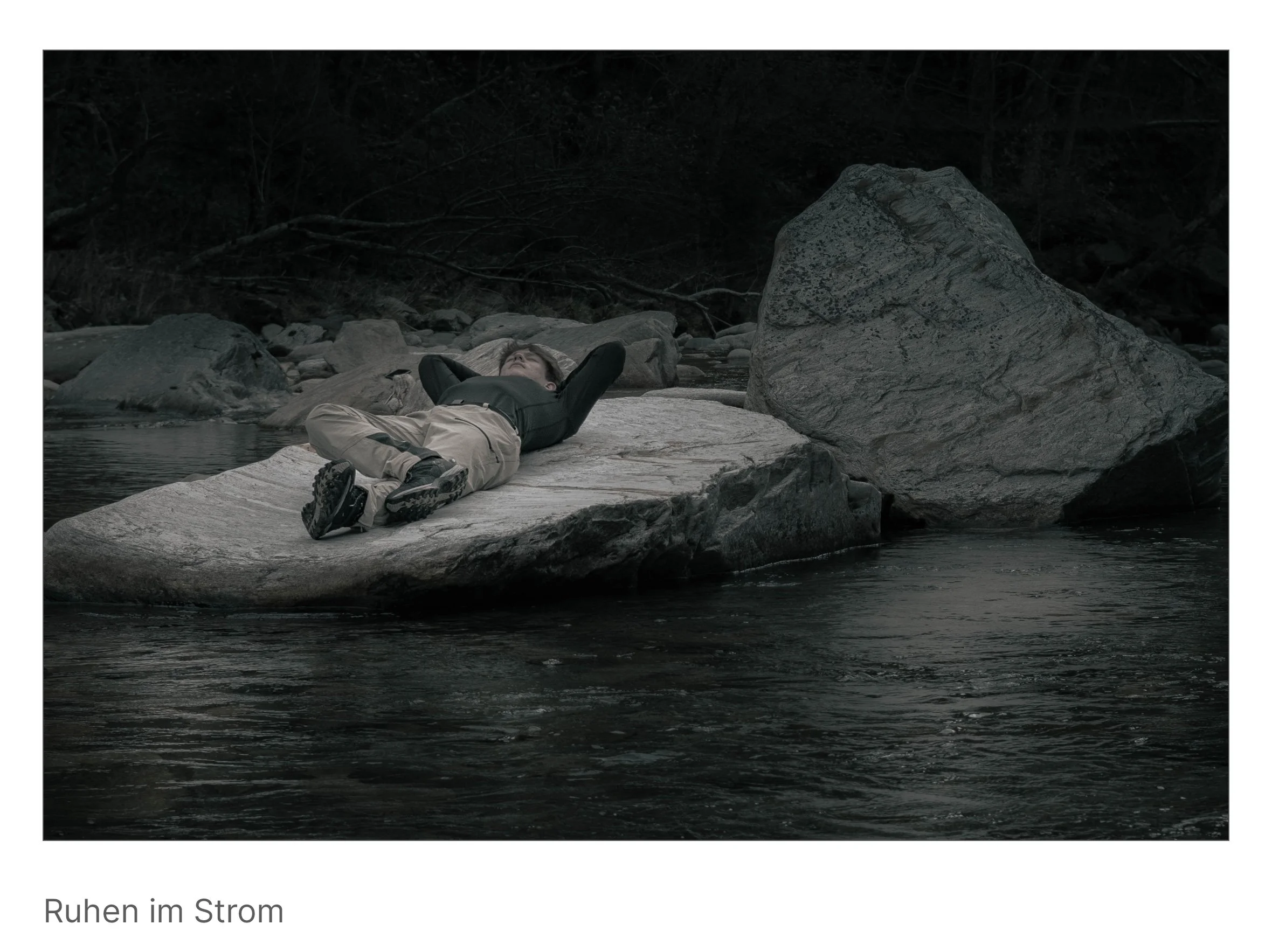 Person liegt entspannt auf Felsen mitten im Fluss – Moment völliger Hingabe an Bewegung und Gleichgewicht.