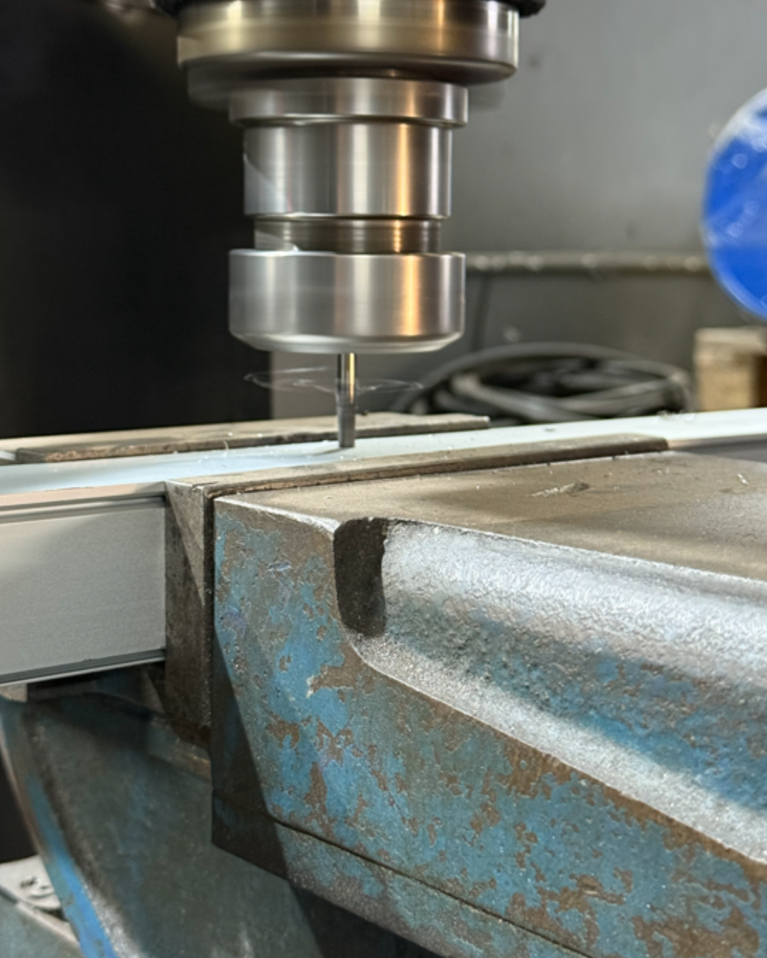Close-up of a CNC machine cutting metal on a workbench in a workshop.