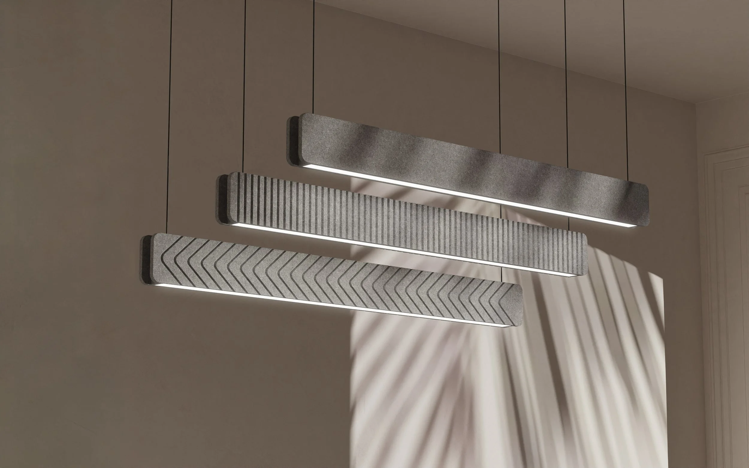 Modern pendant light fixture with three rectangular, ribbed, textured panels hanging from the ceiling, casting shadows on the wall behind.