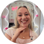 A young woman smiling with pink heart filters and glow effects around her face.