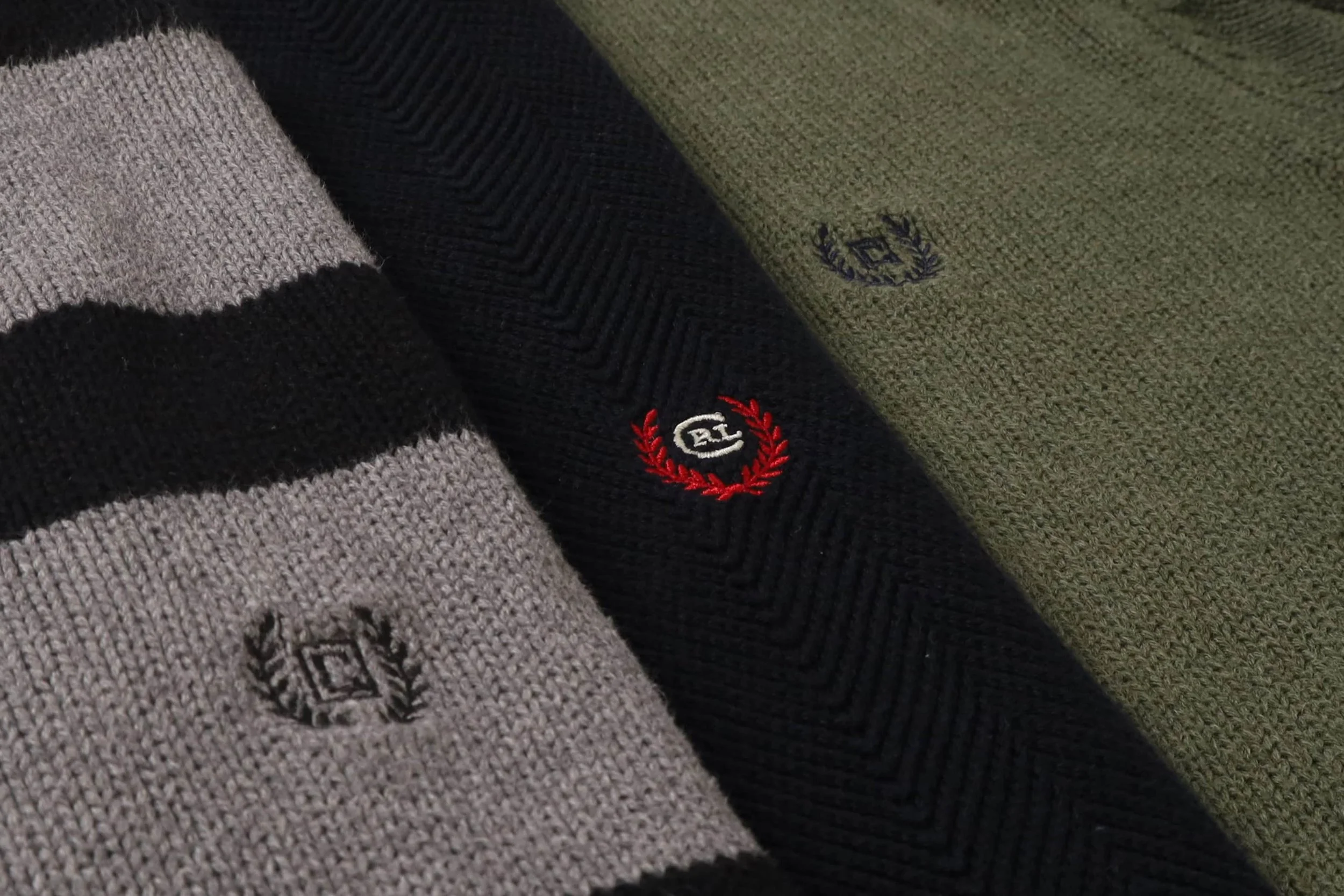 Close-up of three folded striped sweaters with embroidered Ralph Lauren Chaps logos in different colors and designs for Foundry Archives' AW25 Drop.