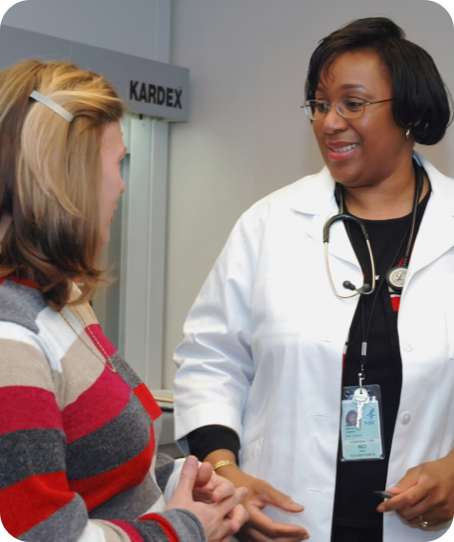 A female doctor talking to a female patient in a medical facility.