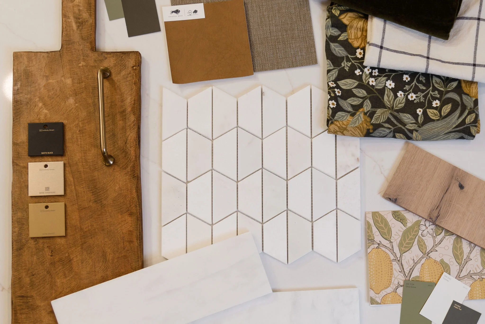 Sample interior design materials including wood, tile, fabric, and color swatches displayed on a table.