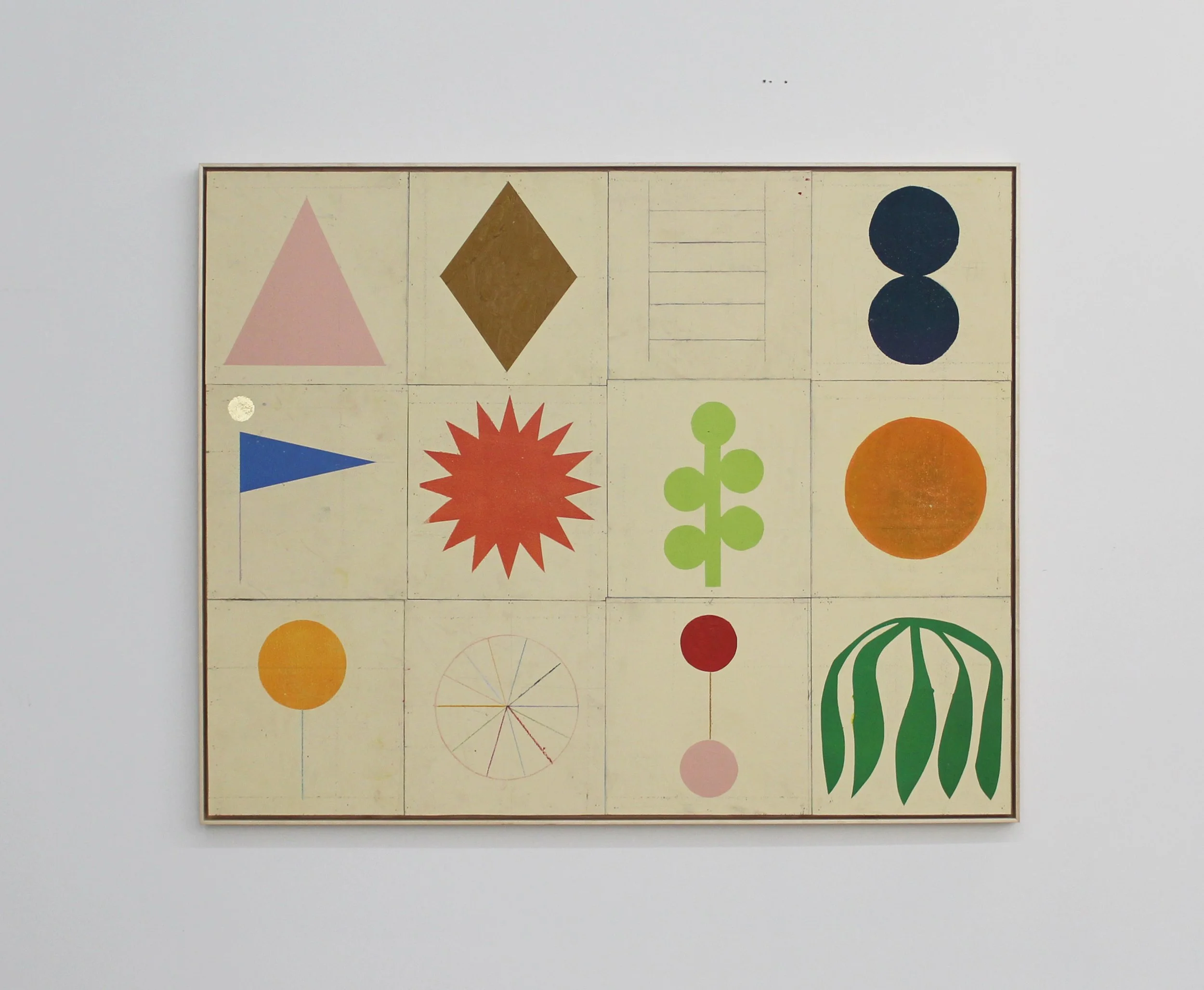 A framed abstract artwork consisting of twelve squares with various geometric and stylized shapes and patterns, including triangles, circles, a diamond, a starburst, a leaf, and other organic and geometric forms, in muted and bright colors on a light