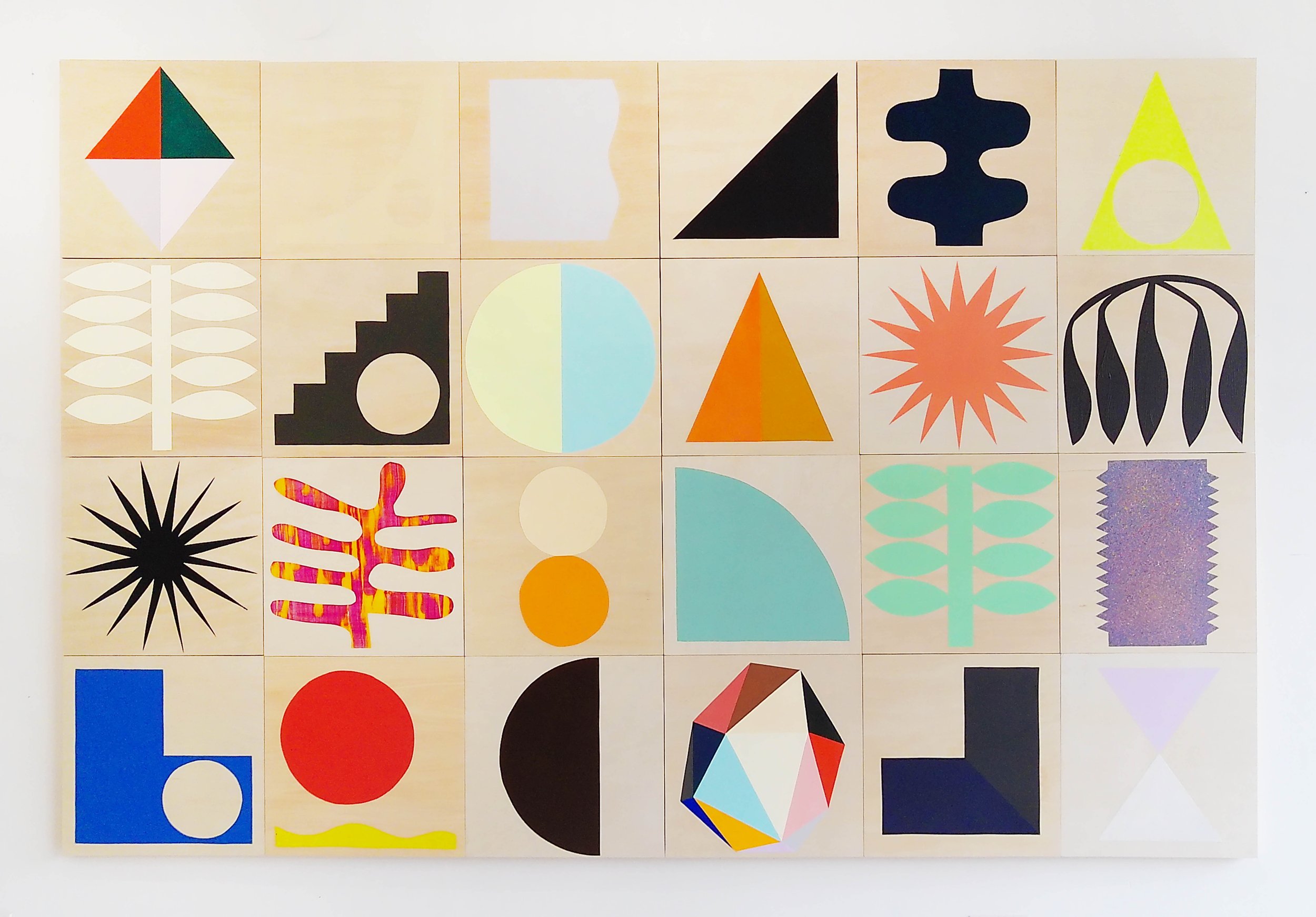 A wall display of colorful geometric patterns and shapes arranged in a grid.