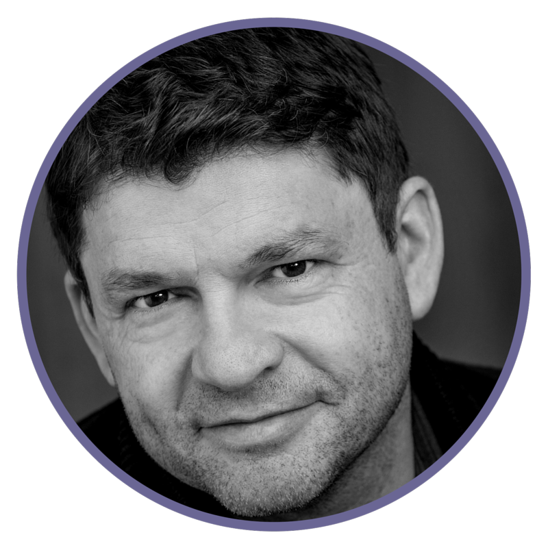 Black and white headshot of man with short, dark hair, smiling slightly, looking directly at the camera.