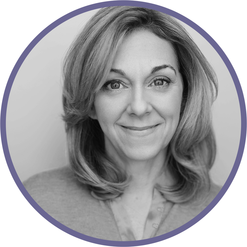 A black and white headshot of a woman with shoulder-length hair, smiling softly at the camera.