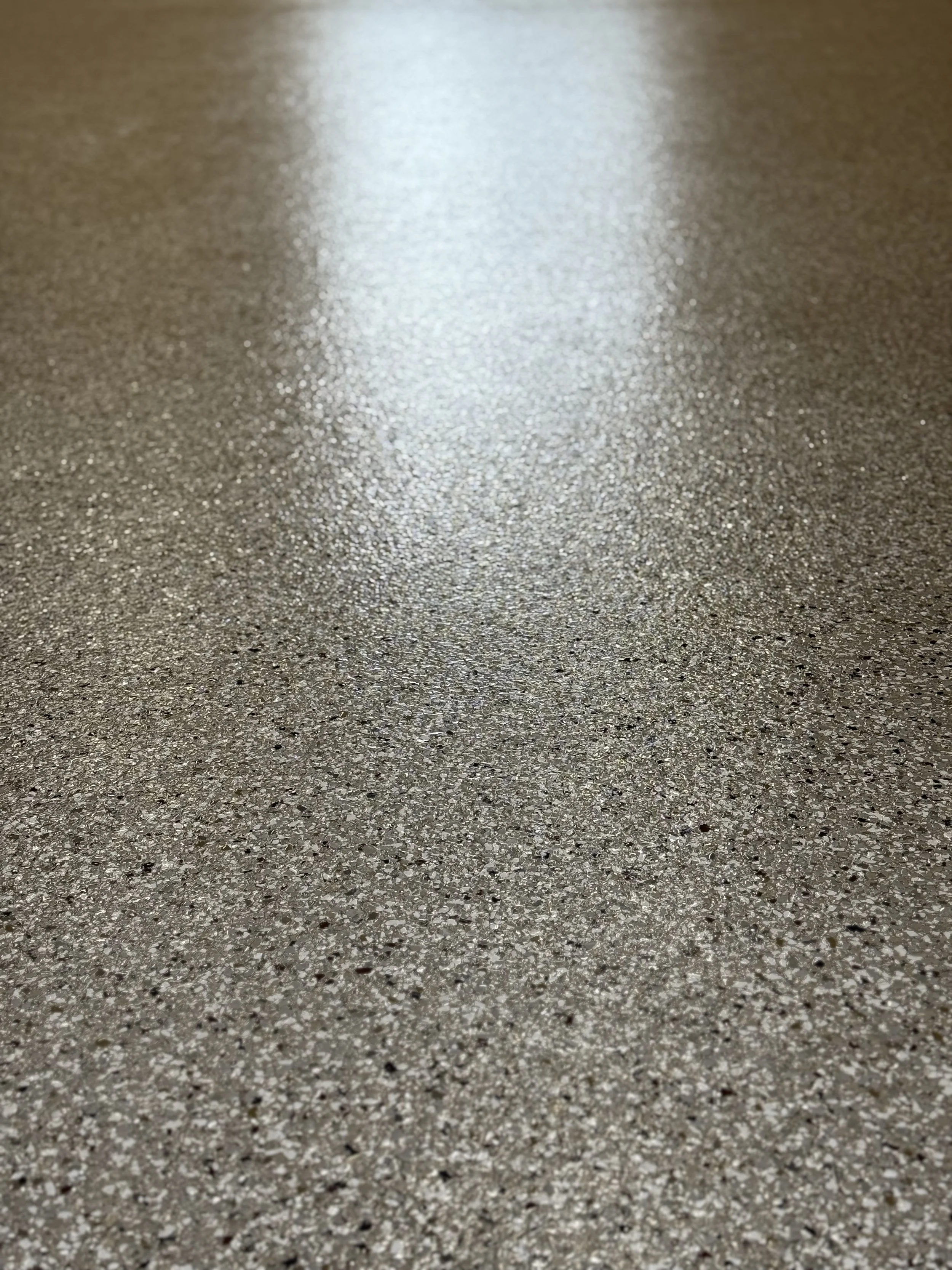 Close-up image of a shiny, textured surface, possibly a countertop or flooring, with a sparkling and reflective appearance.