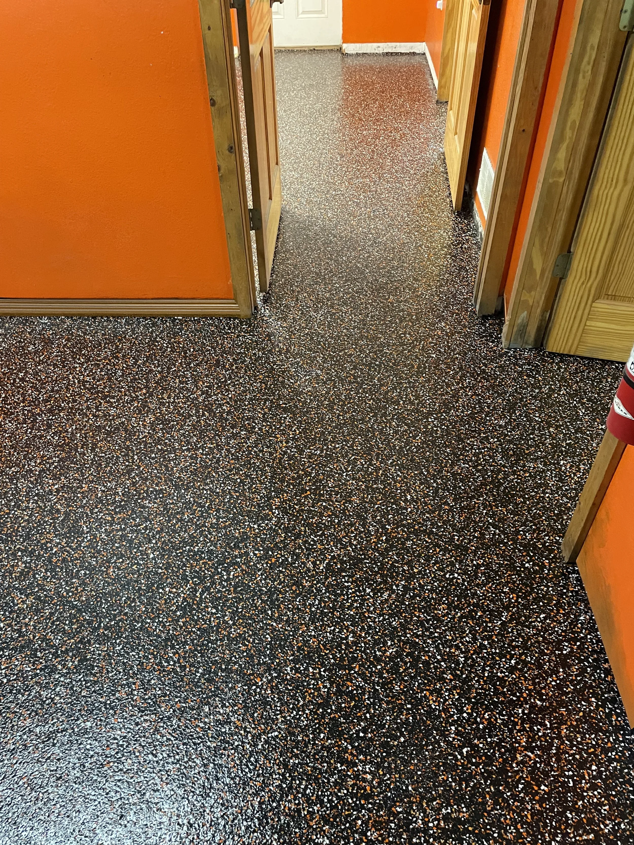 Custom Interior hallway with orange walls and speckled epoxy flooring
