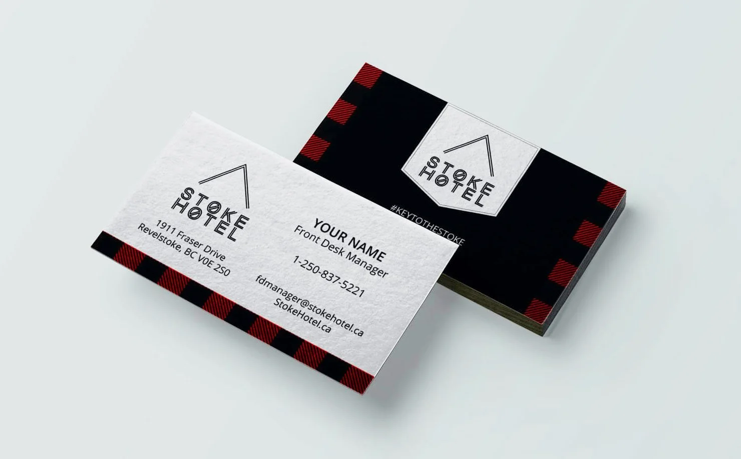 Stack of business cards for Stoke Hotel, featuring a black and red plaid pattern and the hotel's logo with address and contact information.