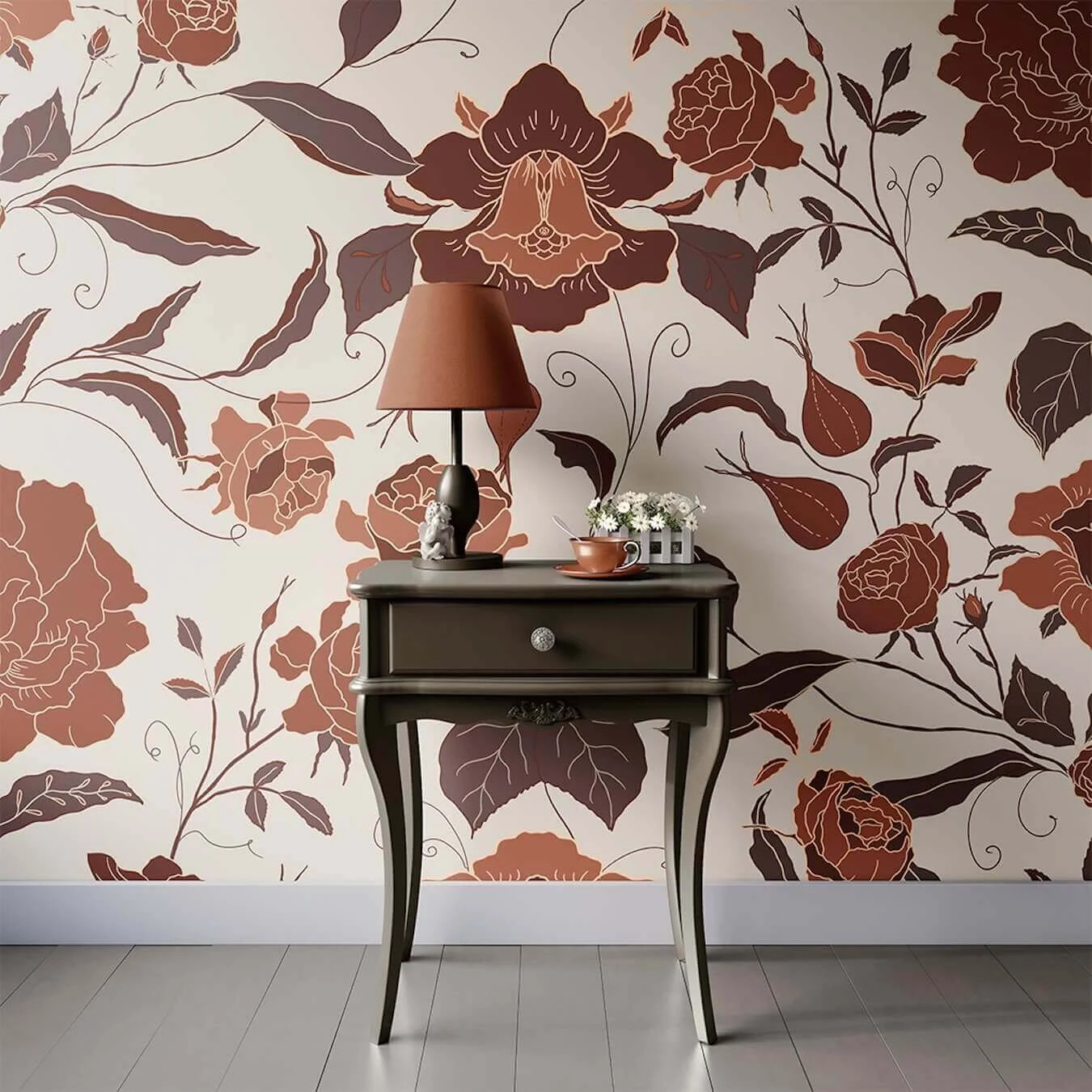 A black vintage side table with curved legs against a floral patterned wallpaper with large brown and beige flowers and leaves. The table holds a brown lampshade lamp, a small ceramic figurine, a flower arrangement with white flowers, and a teacup with a saucer.
