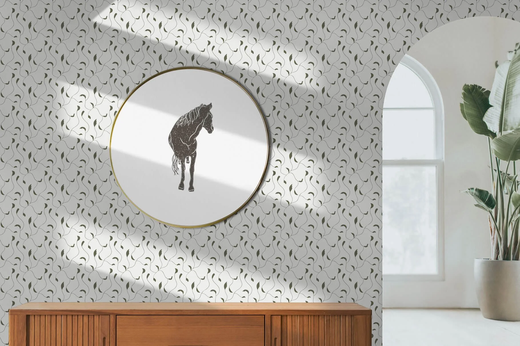 A living room with a patterned wallpaper, a framed black and white horse illustration, a wooden sideboard, a large potted plant, and an arch-shaped window.
