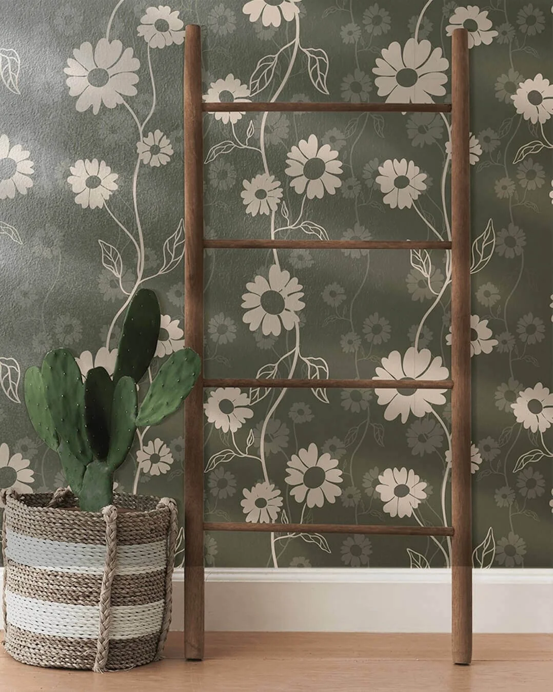 A wooden ladder leaning against a wall with floral wallpaper, and a potted cactus in a woven basket on the floor.