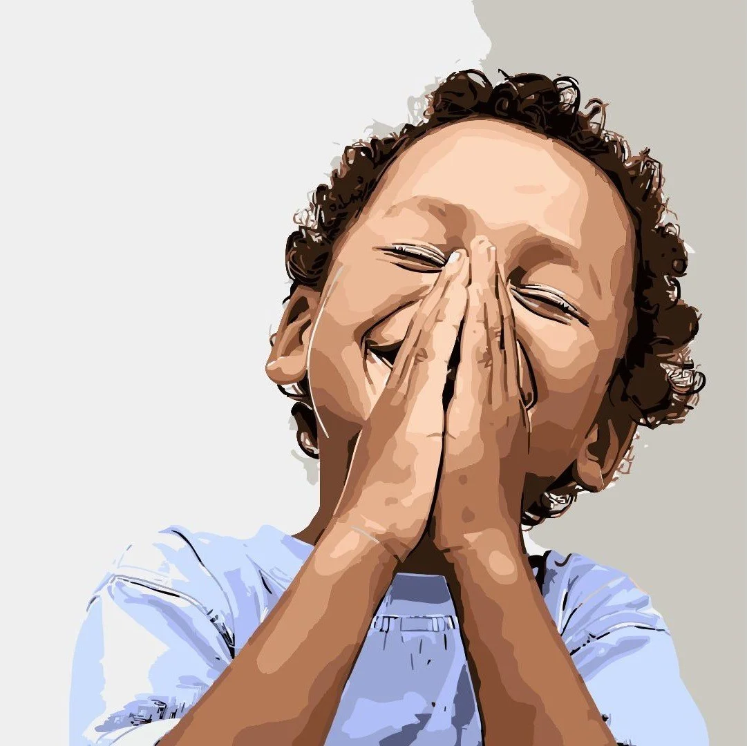A person with curly hair, covering their face with their hands, appearing to laugh or smile.