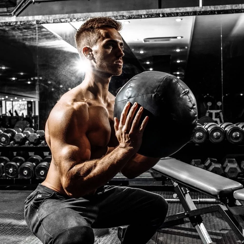 Um homem fazendo wall balls em um box de CrossFit sustentável