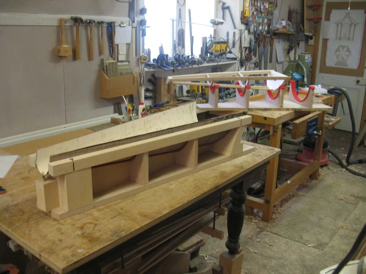 Woodworking workshop with a workbench, clamps, tools, and partially assembled tools.