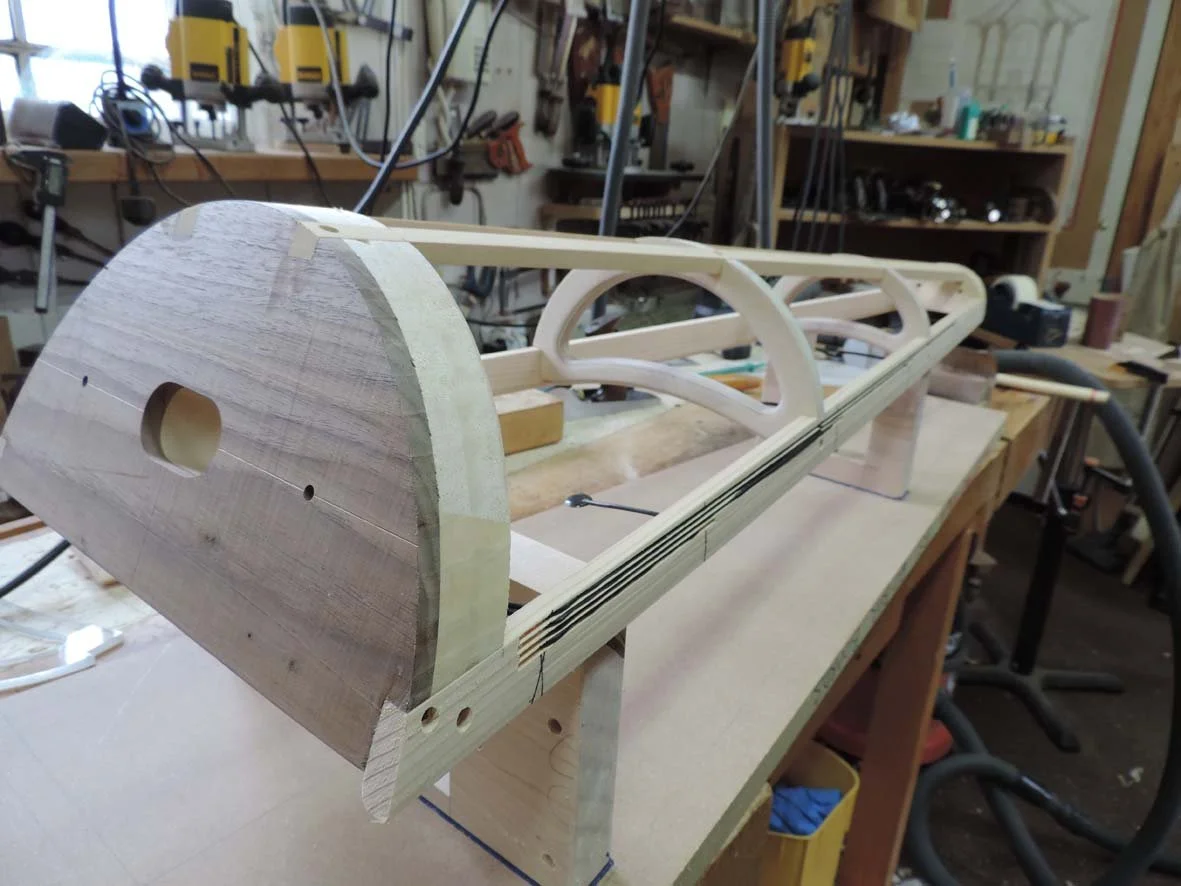 Wooden harp pieces under construction in a workshop.