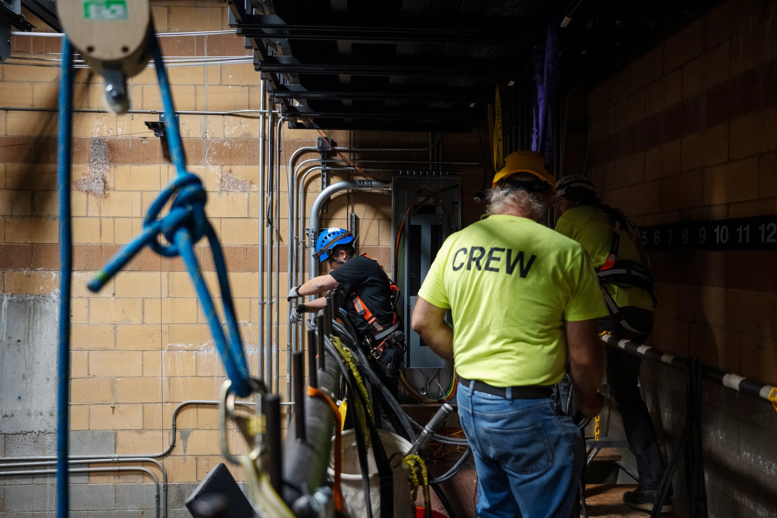 Construction workers, including one with a yellow hard hat and a fluorescent yellow shirt with