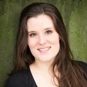 A young woman with long brown hair, smiling, against a textured green background.