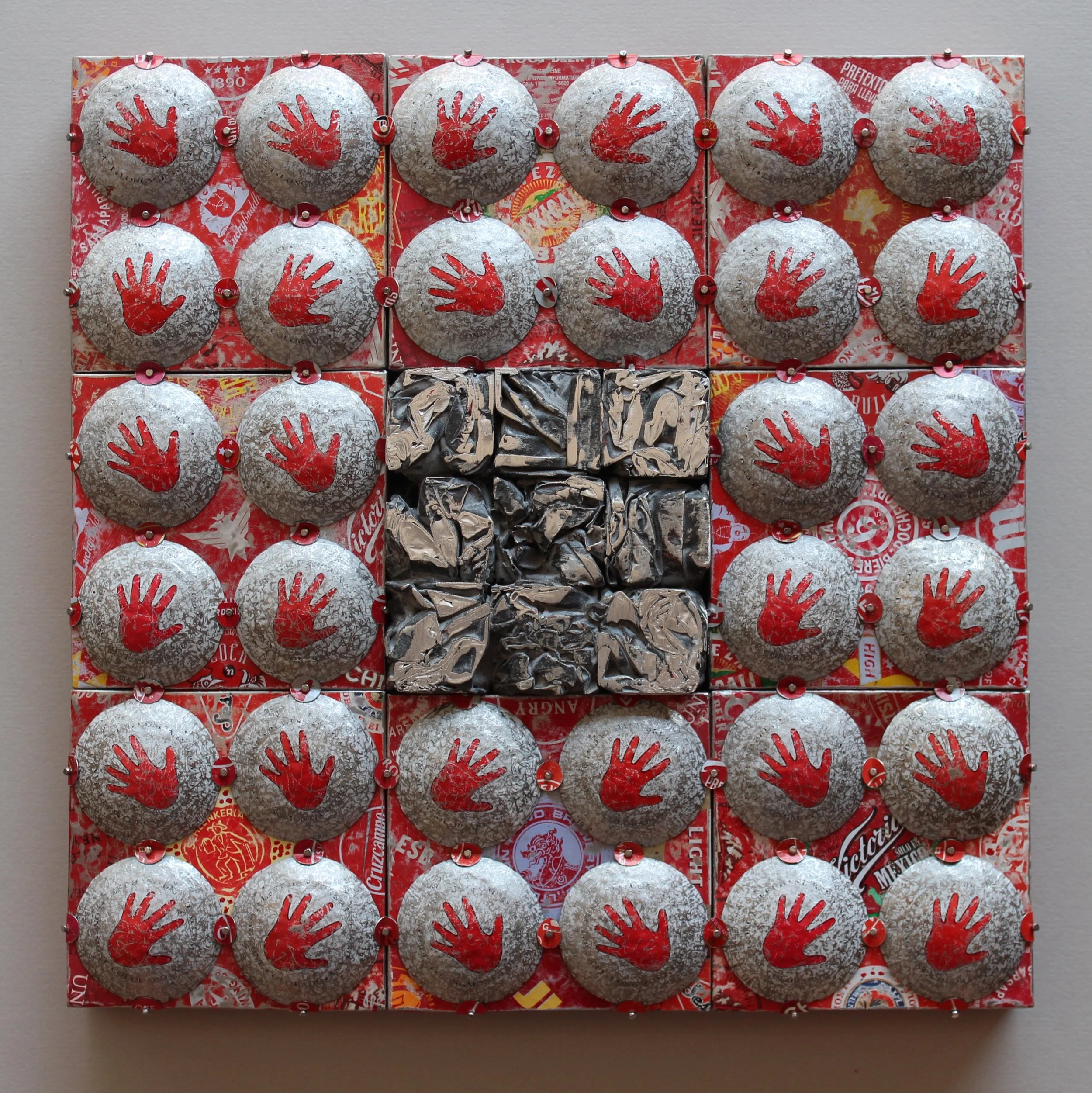 A collage of 25 chocolates arranged in a 5x5 grid with red and silver foil wrapping, including a central square of crinkled silver foil.