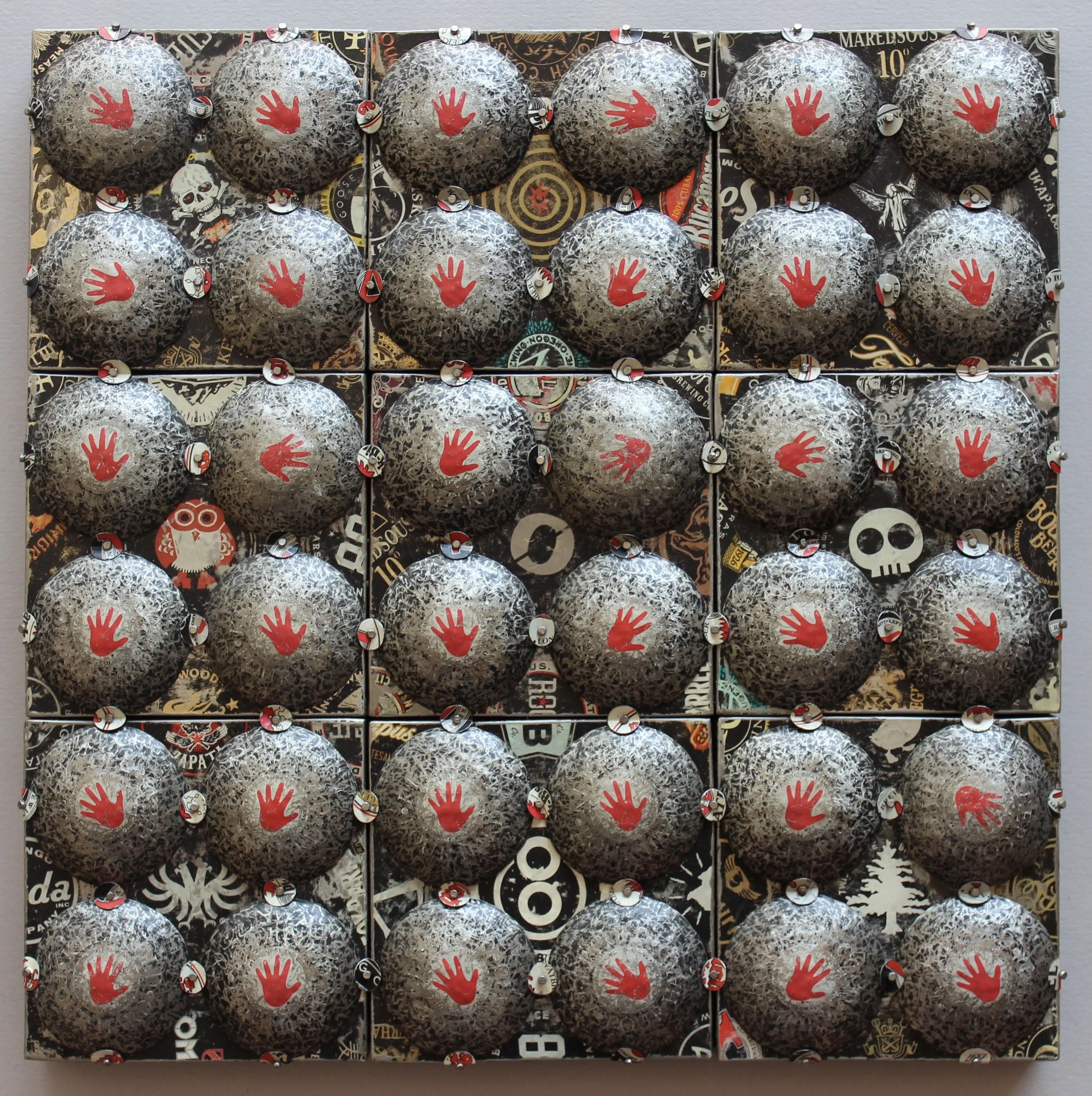 A grid of 16 black and white camouflage-patterned balls with a red hand print on each. The balls are arranged in a 4x4 pattern on a colorful background with various stickers.