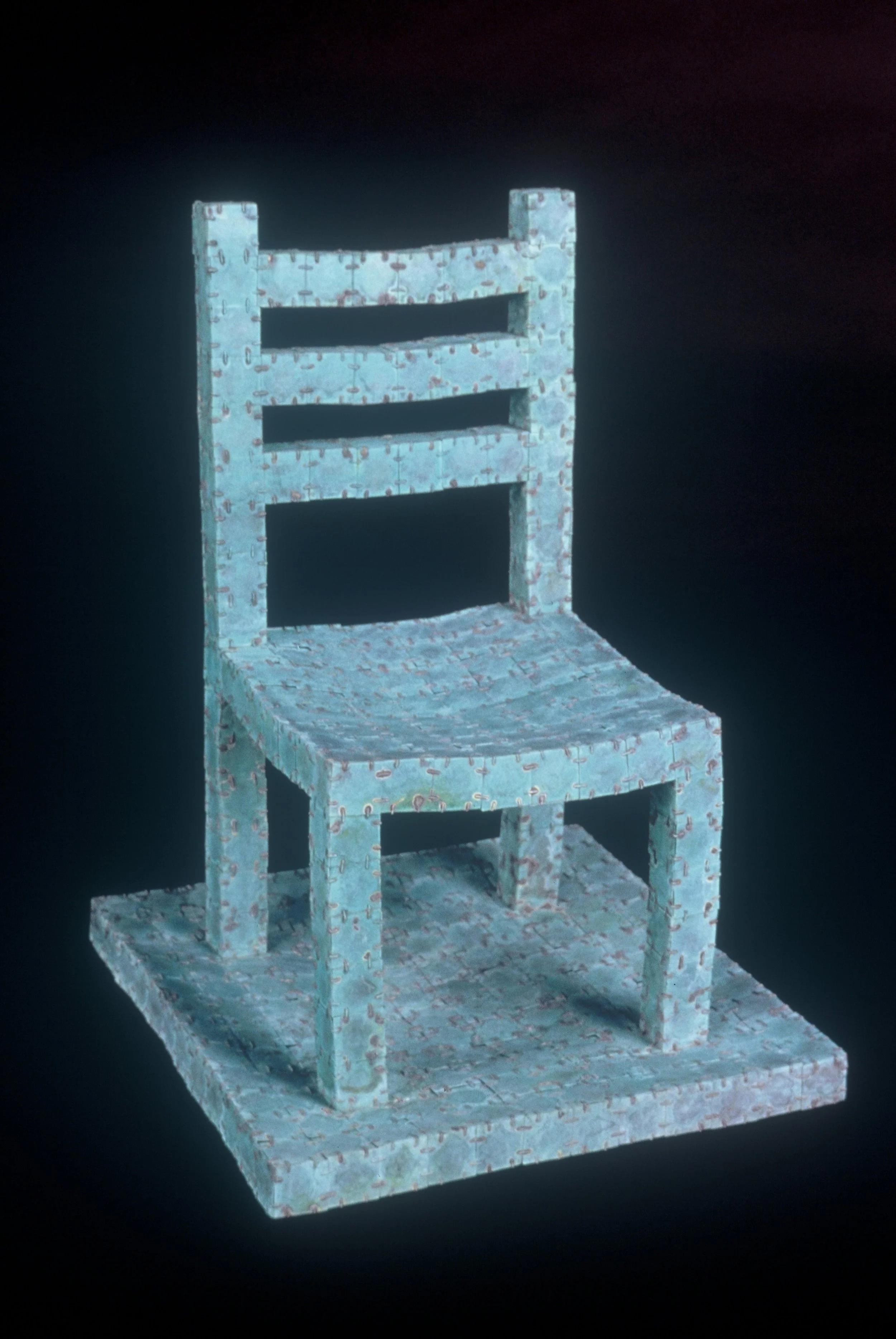 A small chair with a puzzle-piece pattern, placed on a matching puzzle-piece base.