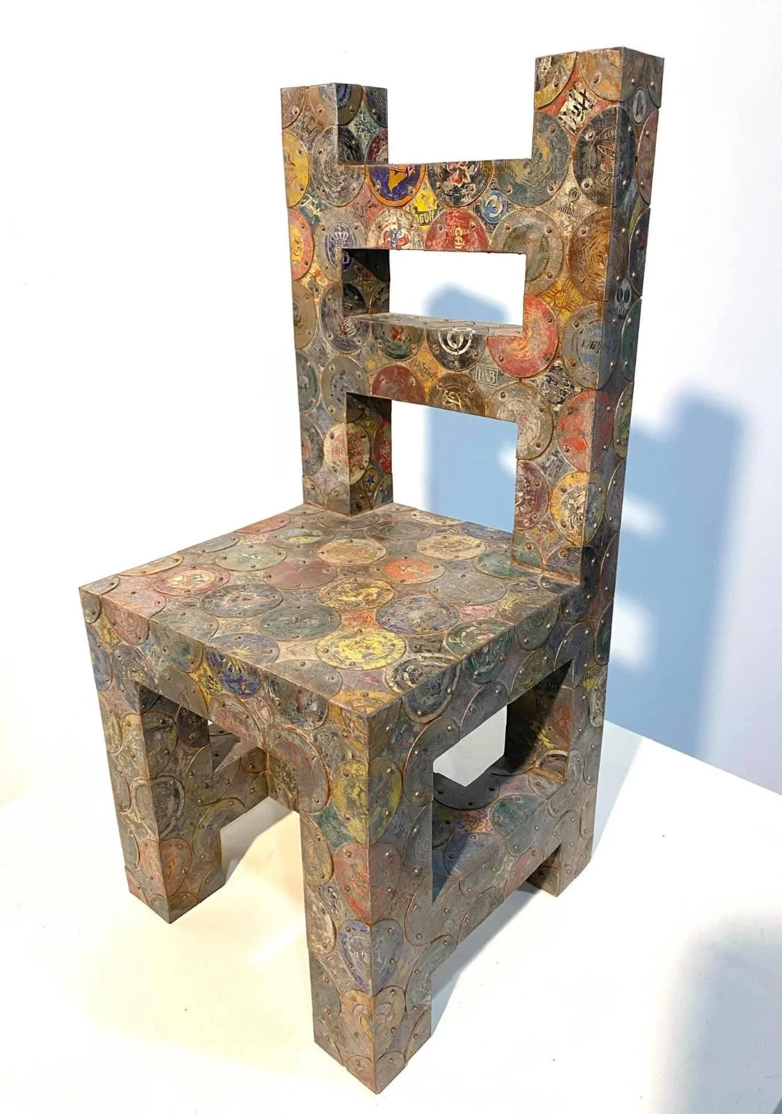 A chair covered in colorful and artistic coin designs.
