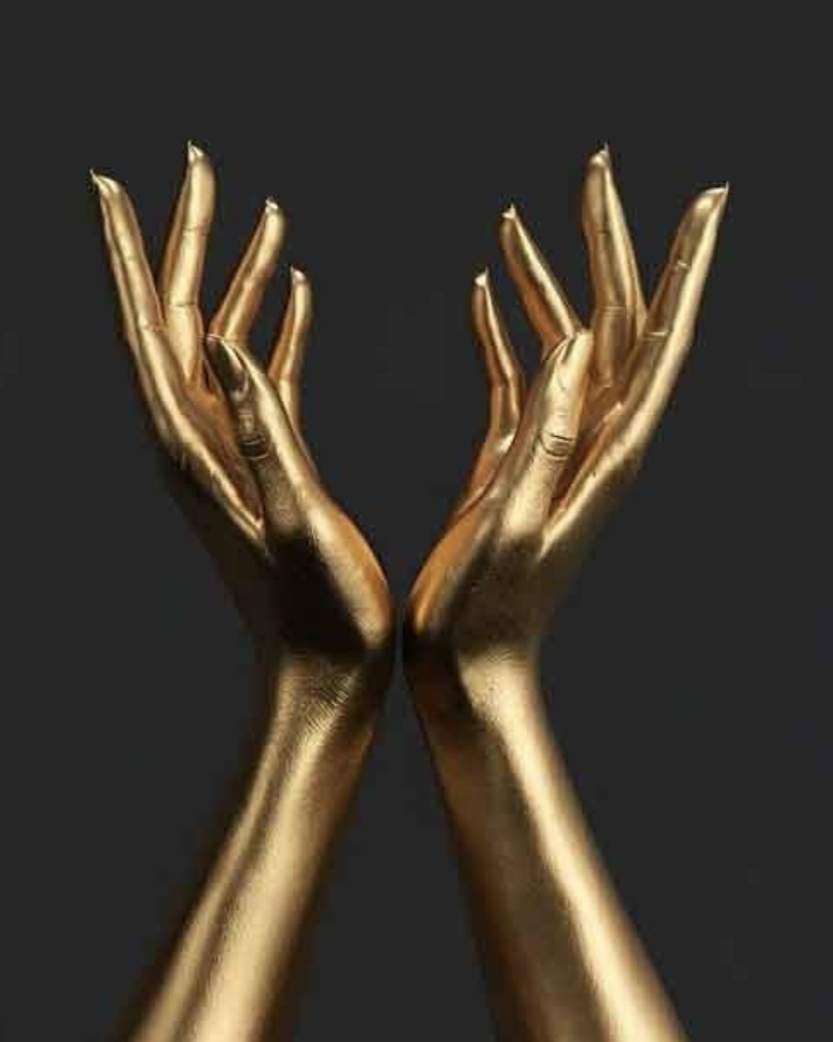 Golden painted hands with open palms in a gesture of elegance against a black background.